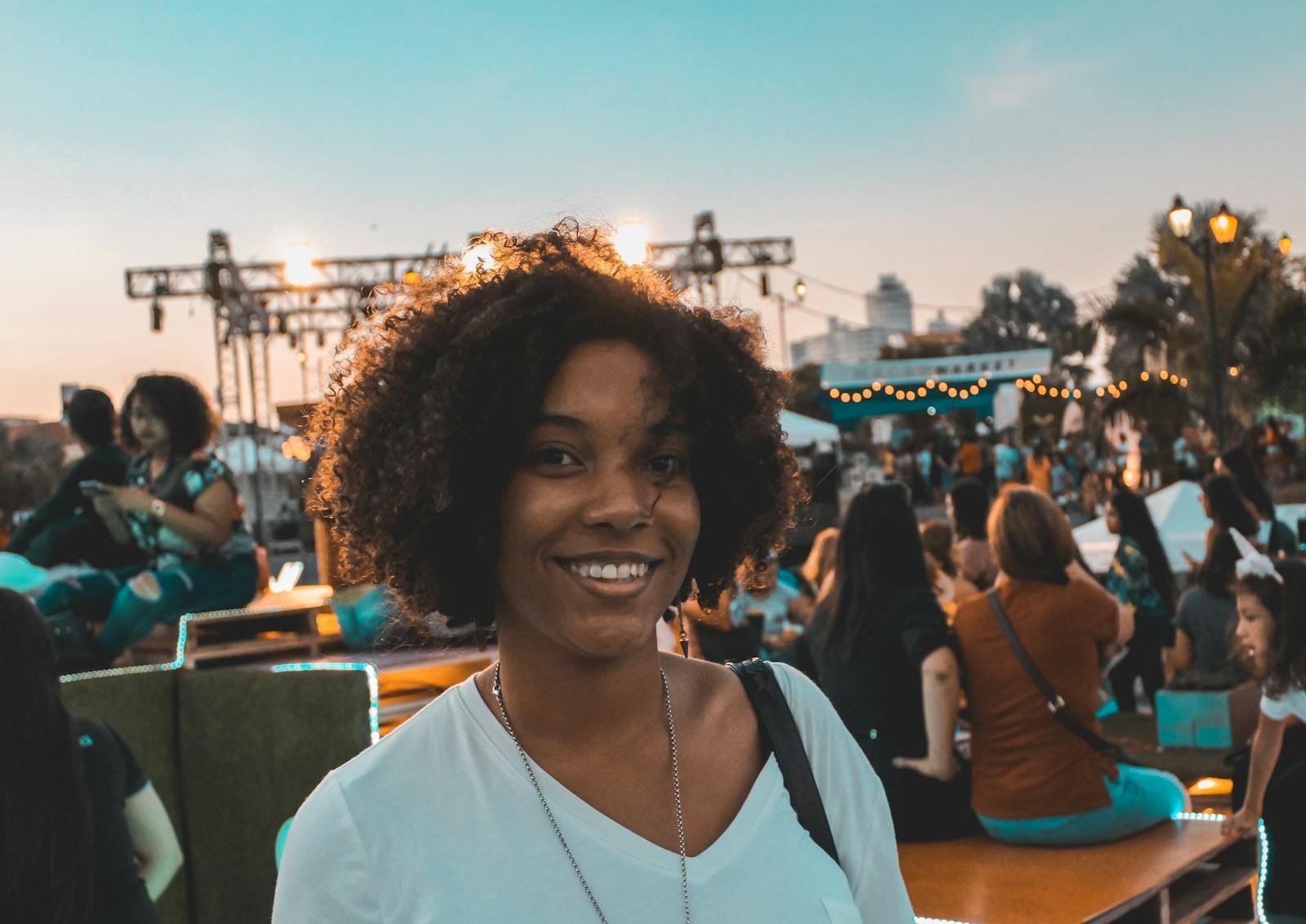 A smiling woman enjoying an outdoor event during sunset in Panama City, Panama.